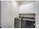 Well lit laundry room features washer, dryer, and white upper cabinets at 8513 Garden View Dr, Charlotte, NC 28277