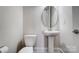 Neutral powder room featuring sleek pedestal sink, modern fixtures and commode at 8513 Garden View Dr, Charlotte, NC 28277