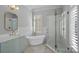 Well-lit bathroom featuring a soaking tub next to a window and glass enclosed shower at 8812 Provence Village Ln, Charlotte, NC 28226
