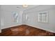 Bright bedroom featuring hardwood floors, multiple windows, and light neutral wall paint at 8812 Provence Village Ln, Charlotte, NC 28226