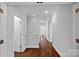 Hallway featuring hardwood floors, white trim and neutral colored walls at 8812 Provence Village Ln, Charlotte, NC 28226