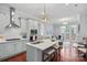 Modern kitchen featuring a breakfast bar, stainless steel appliances, and seamless open floor plan to living room at 8812 Provence Village Ln, Charlotte, NC 28226
