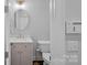 Compact powder room with a small vanity, toilet, and decorative mirror at 8812 Provence Village Ln, Charlotte, NC 28226