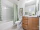 Bright bathroom with a tub-shower combination and a vanity with wooden cabinetry at 9239 Delancey Nw Ln, Concord, NC 28027