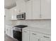 Well-equipped kitchen features white cabinetry, stainless steel appliances, and neutral countertops at 9239 Delancey Nw Ln, Concord, NC 28027