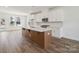 Bright kitchen with island, stainless steel appliances, and tile backsplash opens to the living spaces at 9239 Delancey Nw Ln, Concord, NC 28027