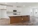 Modern kitchen with a large central island and stainless steel appliances offers plenty of space at 9239 Delancey Nw Ln, Concord, NC 28027