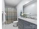 Updated bathroom with gray vanity, marble countertop, decorative mirror, and tiled shower at 1025 Hunter Valley Rd, Shelby, NC 28150