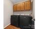Laundry room with overhead cabinets, washer, and dryer with hardwood-style flooring at 1025 Hunter Valley Rd, Shelby, NC 28150