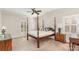 Bedroom with a four poster bed, neutral carpet and wall color, and shuttered windows at 10332 Hollybrook Dr, Charlotte, NC 28277