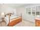 Bedroom featuring a wooden bed frame, neutral carpet, and windows with shutters at 10332 Hollybrook Dr, Charlotte, NC 28277