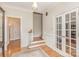 Inviting foyer with hardwood floors, staircase, white trim, and glass-paned French doors at 10332 Hollybrook Dr, Charlotte, NC 28277