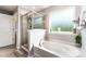 Bathroom features a separate tub, shower with glass door, neutral color scheme, and a window at 1037 Delridge St, Waxhaw, NC 28173