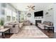 Comfortable living room features a fireplace, ceiling fan, and large windows for natural light at 1037 Delridge St, Waxhaw, NC 28173