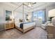Bright bedroom with a four-poster bed, tray ceiling, and an accent chair, perfect for relaxation at 1048 Arundle Rd, Sherrills Ford, NC 28673