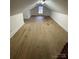 Open attic space featuring wood floors, exposed beam and a window allowing natural light at 10516 Hambright Rd, Huntersville, NC 28078