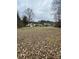 Wide shot of the backyard with a house in the distance and covered in fallen leaves at 10516 Hambright Rd, Huntersville, NC 28078