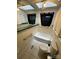 Bathroom featuring a white tub, toilet, grab bars, tiled floor and a window with black curtains at 10516 Hambright Rd, Huntersville, NC 28078