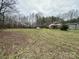 Wide backyard featuring a home, utility buildings, and abundant natural surroundings at 10516 Hambright Rd, Huntersville, NC 28078