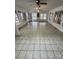Open floor living room features tile flooring, multiple windows, a ceiling fan and several entrances at 10516 Hambright Rd, Huntersville, NC 28078