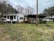 Rear exterior of a white house with an attached carport, wooden deck, and a large backyard at 10516 Hambright Rd, Huntersville, NC 28078