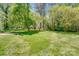 Picturesque backyard showcasing the well-manicured lawn, mature trees, and partial view of the home at 11003 Pale Hickory Ln, Charlotte, NC 28215