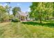 Beautiful backyard featuring a lush lawn and the home's exterior with a covered porch and patio at 11003 Pale Hickory Ln, Charlotte, NC 28215