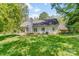 Expansive backyard featuring a lush lawn, and the home's exterior with a covered porch and patio at 11003 Pale Hickory Ln, Charlotte, NC 28215