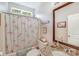 Bright bathroom featuring a shower with a floral curtain, granite sink, and a framed mirror at 11003 Pale Hickory Ln, Charlotte, NC 28215