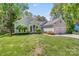 Inviting home featuring a lush green lawn, mature trees, and a convenient two-car garage at 11003 Pale Hickory Ln, Charlotte, NC 28215