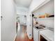 Convenient laundry room featuring a washer, dryer, storage shelves, and hardwood floors at 11003 Pale Hickory Ln, Charlotte, NC 28215