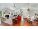 Open-concept living room with fireplace, vaulted ceiling, wood floors, and dining area at 11003 Pale Hickory Ln, Charlotte, NC 28215
