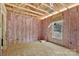 Unfinished bedroom featuring wall insulation, a window, and wood flooring at 1235 E Poplar St, Conover, NC 28613