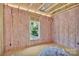 Unfinished bedroom featuring wall insulation, a window, and wood flooring at 1235 E Poplar St, Conover, NC 28613