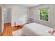 White bedroom with hardwood floors, ample sunlight, and closet with storage at 1327 Cedarwood Ln, Charlotte, NC 28212