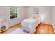 Cozy bedroom featuring white bedding, light hardwood floors, and a picture window at 1327 Cedarwood Ln, Charlotte, NC 28212