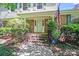Inviting brick home entrance with American flag, landscaped shrubs and front steps at 1327 Cedarwood Ln, Charlotte, NC 28212