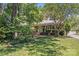Traditional home featuring a lush, green lawn, mature trees and a charming front entrance at 1327 Cedarwood Ln, Charlotte, NC 28212