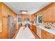 Well-lit kitchen featuring light wood cabinets, stainless steel refrigerator and island with white countertop at 1327 Cedarwood Ln, Charlotte, NC 28212