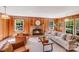 Cozy living room showcases wood paneling, a brick fireplace, and comfortable seating at 1327 Cedarwood Ln, Charlotte, NC 28212