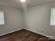 Neutral bedroom with hardwood floors and natural light from two windows at 13316 E Rocky River Rd, Davidson, NC 28036