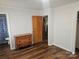 Clean bedroom with a closet, dresser, neutral walls, and dark wood floors at 13316 E Rocky River Rd, Davidson, NC 28036
