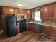 Well-lit kitchen with wooden cabinets, sleek black appliances, and durable countertops at 13316 E Rocky River Rd, Davidson, NC 28036