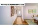 Hallway with hardwood floors, decorative wall art, and access to dining area at 134 Woodhall Way, Troutman, NC 28166