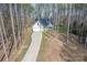 Picturesque aerial view of a home nestled in a forest with a long driveway at 13625 Buster Rd, Stanfield, NC 28163