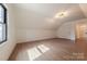 Open attic space with sleek wood laminate flooring, crisp white walls, and bright natural light at 13625 Buster Rd, Stanfield, NC 28163