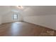 Bright attic space with a window allowing natural light to accent the wood laminate flooring at 13625 Buster Rd, Stanfield, NC 28163