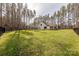 Expansive backyard enclosed by a black metal fence, offering privacy with abundant trees surrounding the property at 13625 Buster Rd, Stanfield, NC 28163