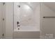 Clean, bright bathroom featuring a shower-tub with marble tiling and modern fixtures at 13625 Buster Rd, Stanfield, NC 28163