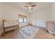Bright bedroom with a neutral palette, ceiling fan, window, and a crib with wood-look floors at 13625 Buster Rd, Stanfield, NC 28163